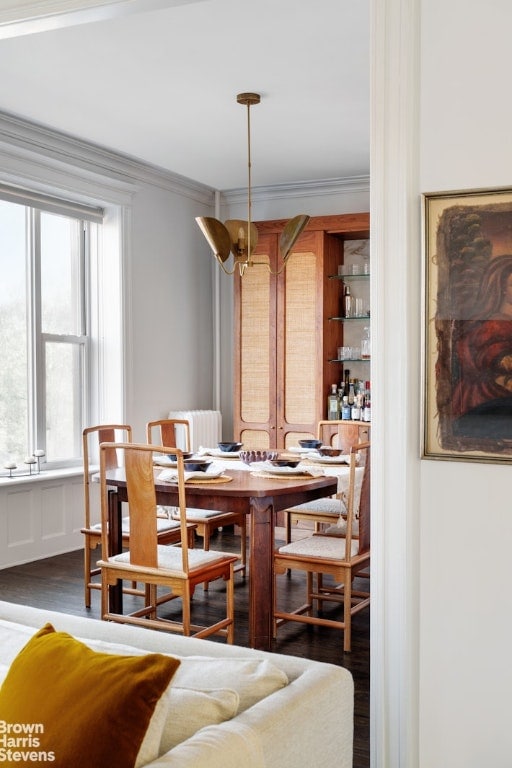 dining room with crown molding, dark hardwood / wood-style floors, and an inviting chandelier