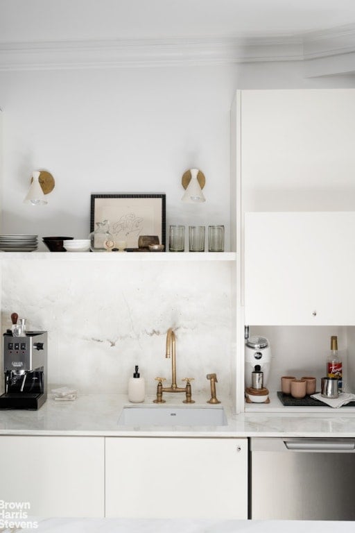 bar with ornamental molding, sink, and white cabinets