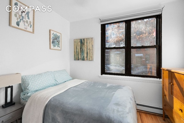 bedroom featuring a baseboard radiator and wood-type flooring