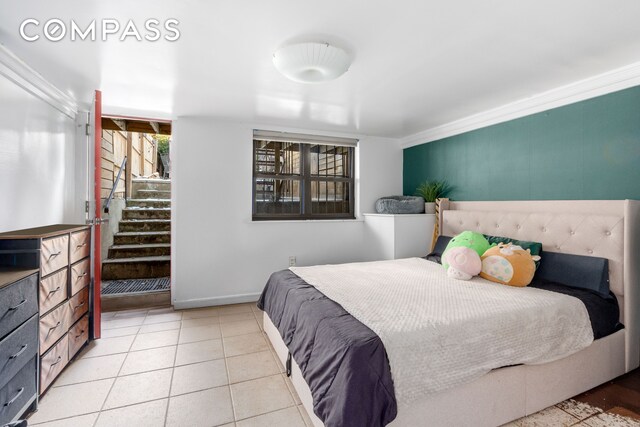 bedroom with baseboards, crown molding, and tile patterned flooring