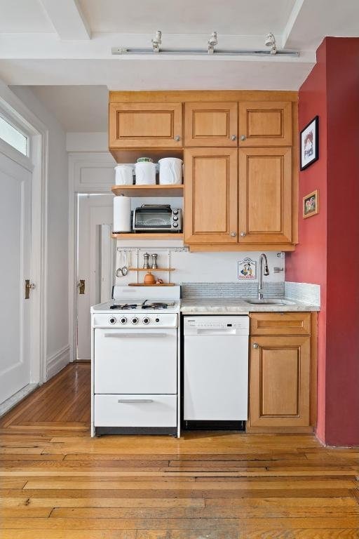 kitchen with sink, white appliances, and light hardwood / wood-style floors