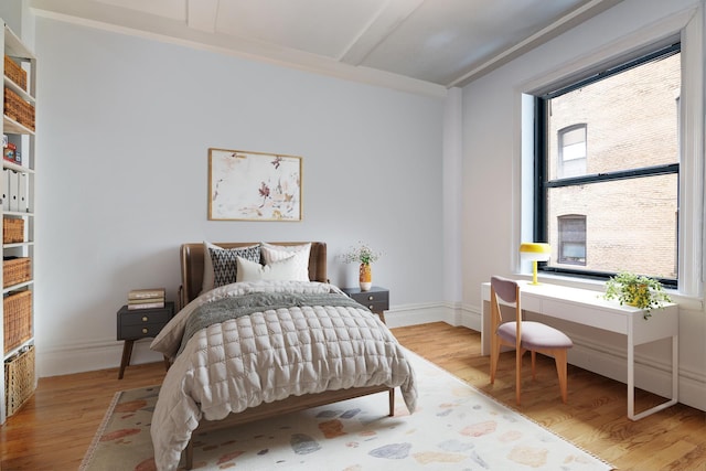 bedroom featuring baseboards and wood finished floors