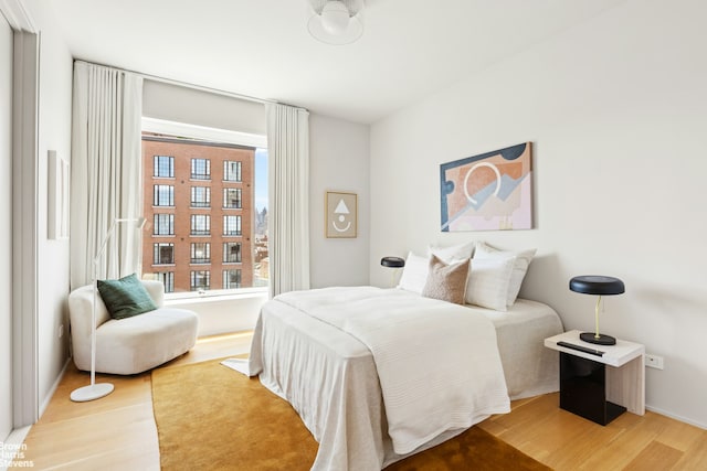 bedroom featuring multiple windows and light wood-style flooring