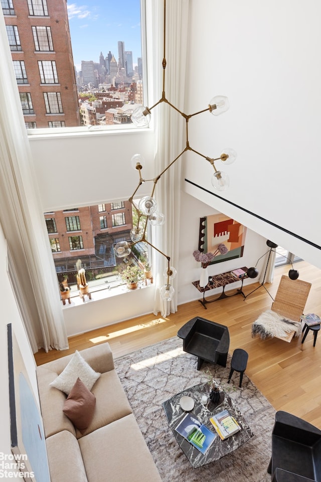 living area featuring a high ceiling, stairway, a city view, and wood finished floors