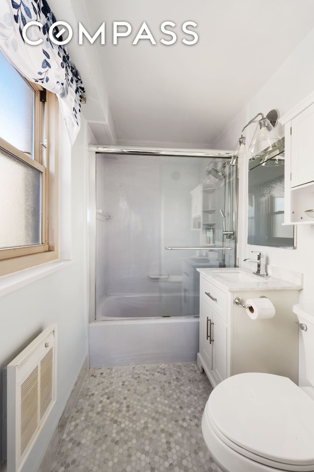 bathroom with visible vents, bath / shower combo with glass door, vanity, and toilet