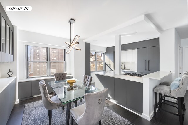 dining space featuring an inviting chandelier, dark hardwood / wood-style floors, and sink