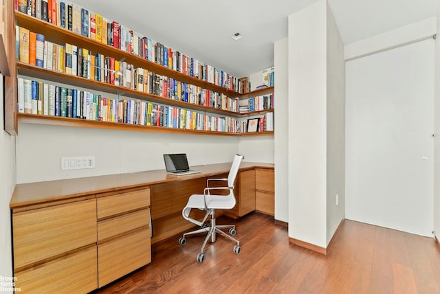 office area featuring wood-type flooring and built in desk