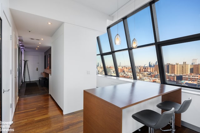 office with visible vents, recessed lighting, a view of city, and dark wood-style flooring