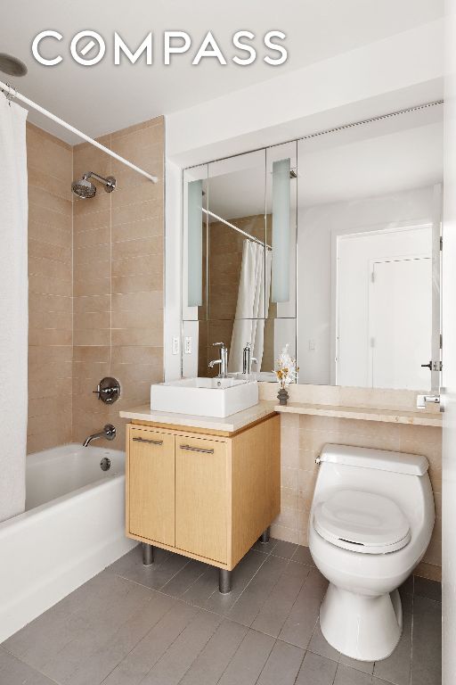 full bathroom featuring tile patterned flooring, vanity, shower / tub combo, and toilet