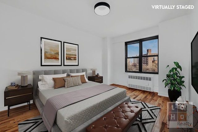 bedroom featuring radiator heating unit and wood finished floors