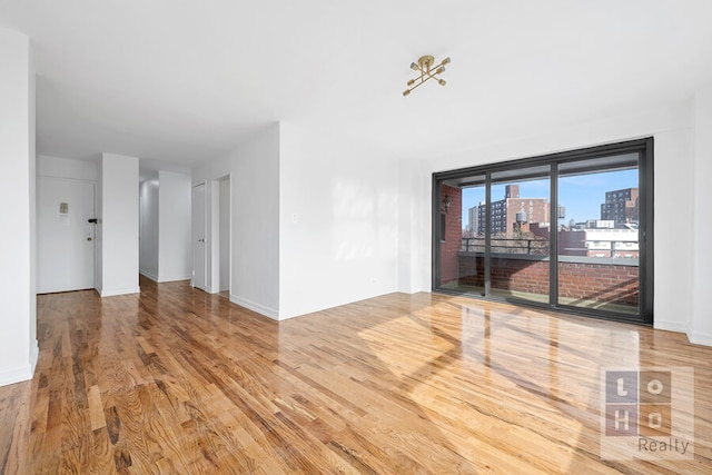 spare room featuring a view of city and wood finished floors