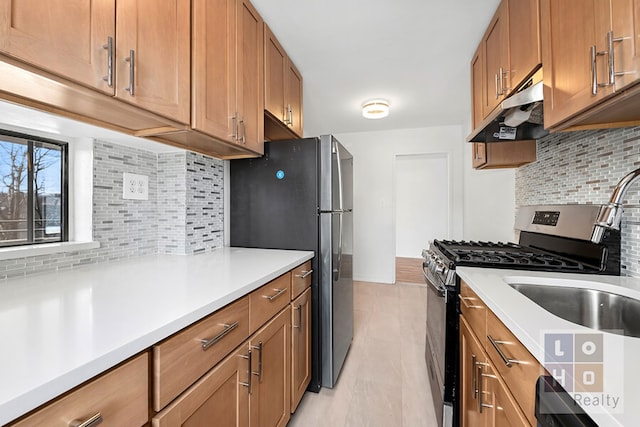 kitchen featuring appliances with stainless steel finishes, brown cabinetry, and under cabinet range hood