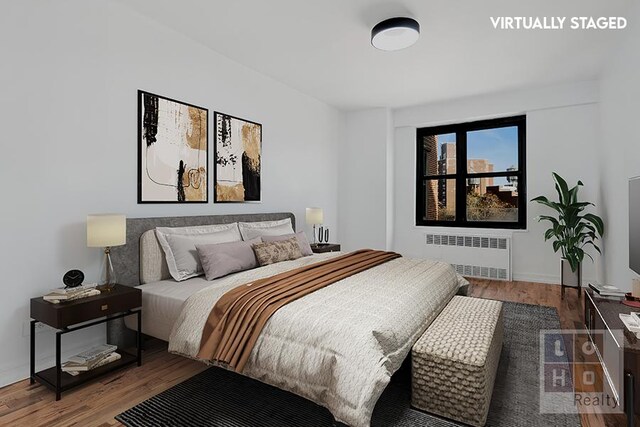 bedroom featuring hardwood / wood-style floors and radiator heating unit