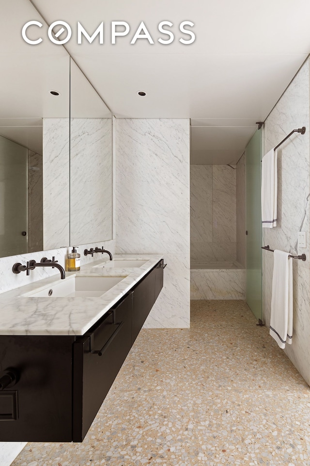 bathroom with double vanity and a shower