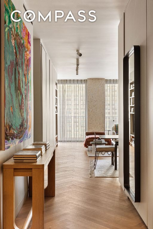 hallway with a wall of windows and light wood-type flooring