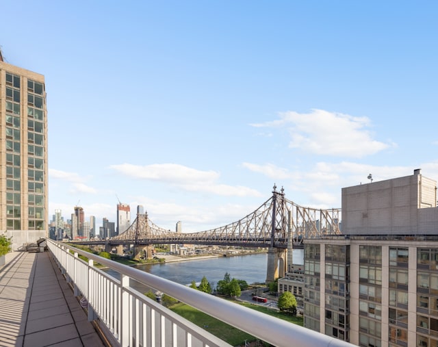 balcony featuring a water view and a city view