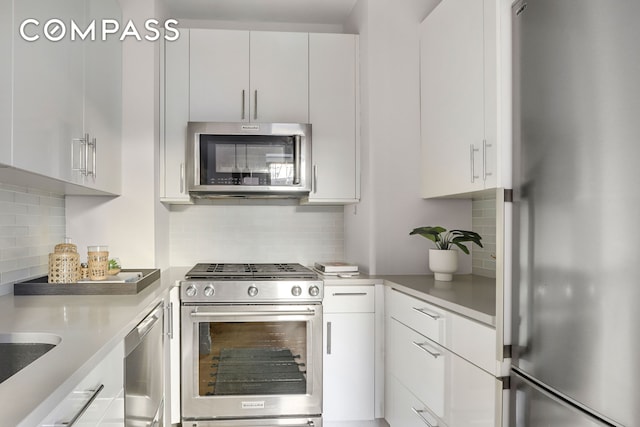 kitchen with white cabinetry, backsplash, appliances with stainless steel finishes, and light countertops