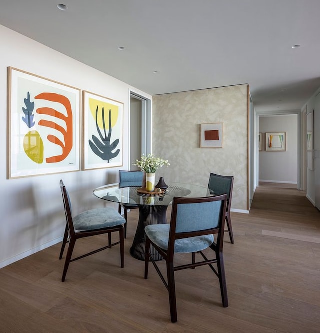dining space with baseboards and wood finished floors