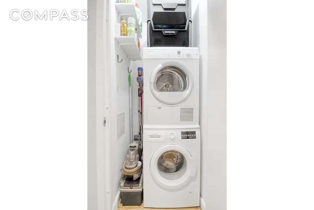 clothes washing area with laundry area and stacked washing maching and dryer