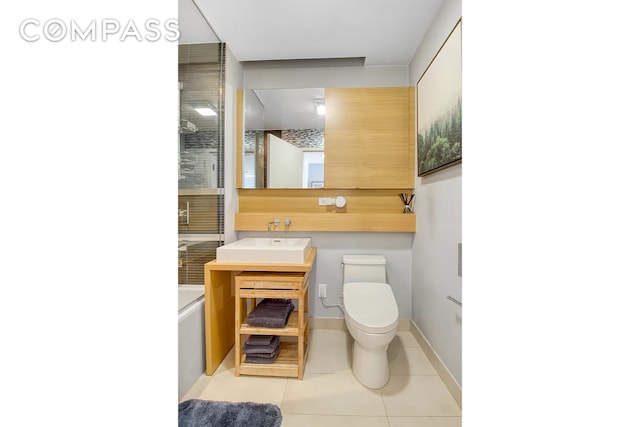 full bath with vanity, baseboards, tile patterned flooring, walk in shower, and toilet