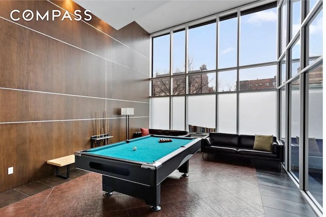 game room with pool table, floor to ceiling windows, and a high ceiling