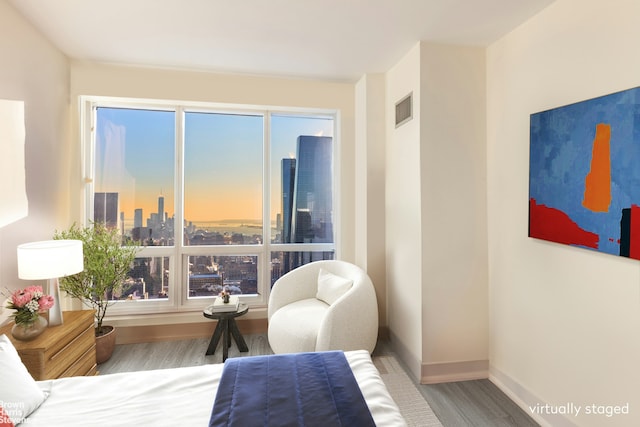 350 W 42nd St Unit 53F, New York City, NY 10036 - bedroom featuring wood finished floors, baseboards, a view of skyline, and multiple windows
