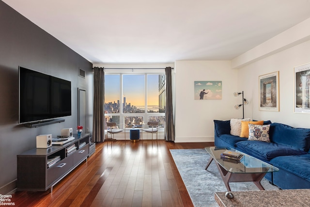 living area featuring baseboards and dark wood-style flooring