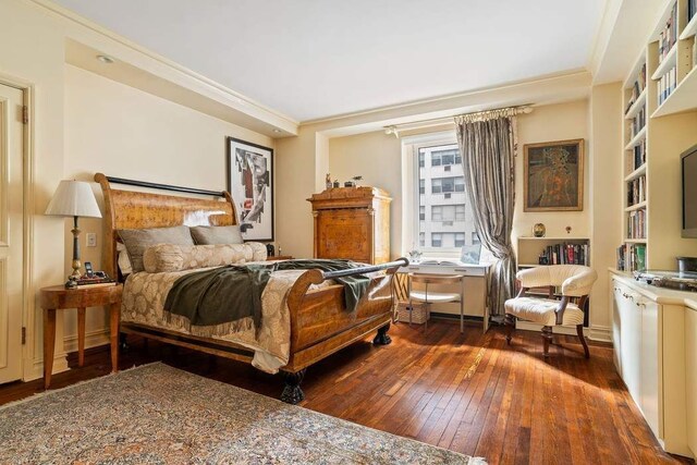 bedroom featuring ornamental molding and dark hardwood / wood-style flooring