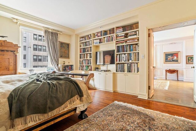 bedroom featuring crown molding and wood-type flooring