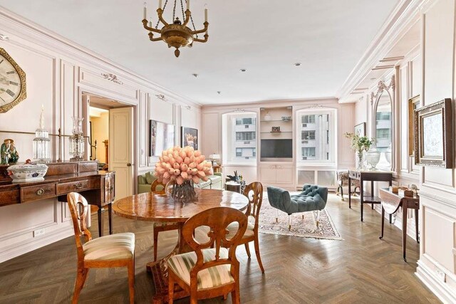 living room with crown molding, a healthy amount of sunlight, and dark parquet flooring