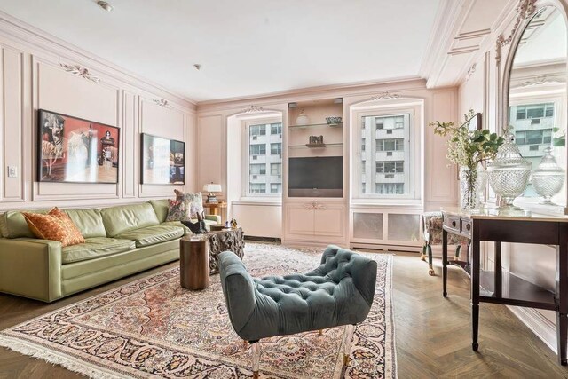 living room with crown molding, a chandelier, and hardwood / wood-style flooring