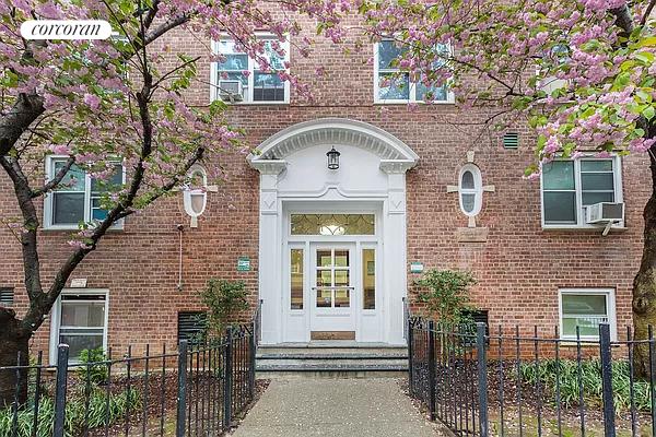 property entrance featuring french doors, brick siding, and fence