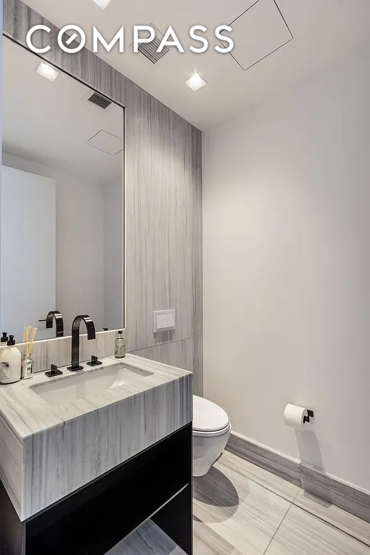 111 Murray St Unit 44W, New York City, NY 10007 - half bathroom featuring toilet, vanity, and baseboards