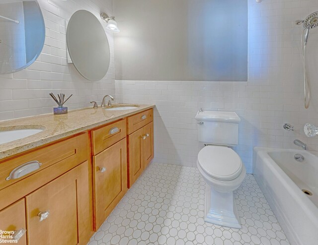 full bathroom featuring vanity, bathtub / shower combination, tile walls, and toilet