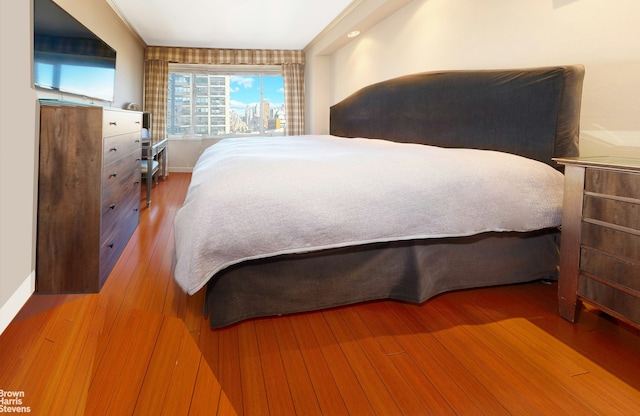 bedroom with baseboards and wood finished floors