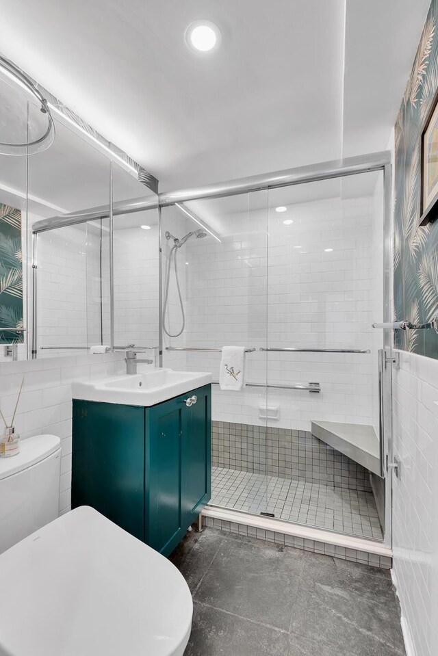 bathroom featuring vanity, tile walls, an enclosed shower, and toilet