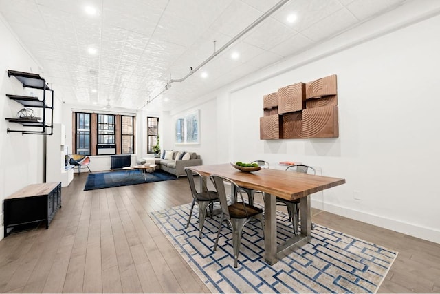 dining room featuring wood-type flooring and rail lighting