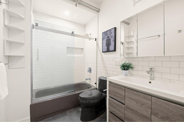 full bath featuring toilet, tasteful backsplash, shower / bath combination with glass door, tile walls, and vanity