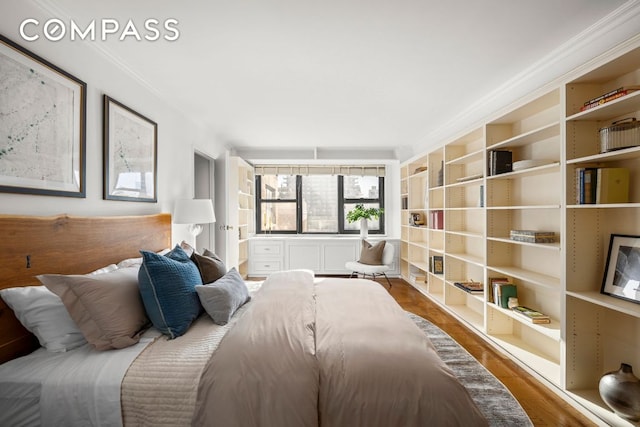 bedroom with hardwood / wood-style flooring and ornamental molding