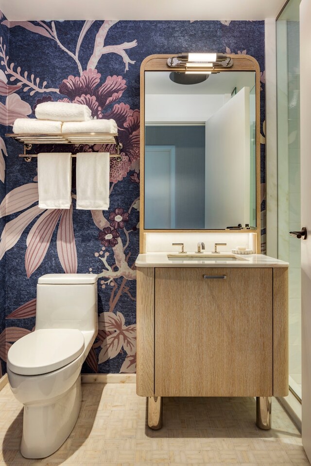 bathroom featuring wallpapered walls, toilet, and vanity