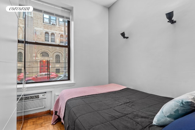 bedroom with parquet flooring and an AC wall unit