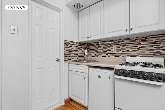 kitchen featuring sink, white appliances, decorative backsplash, and white cabinets