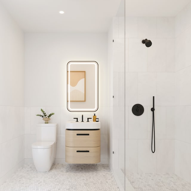 bathroom with tiled shower, tile patterned floors, toilet, tile walls, and vanity