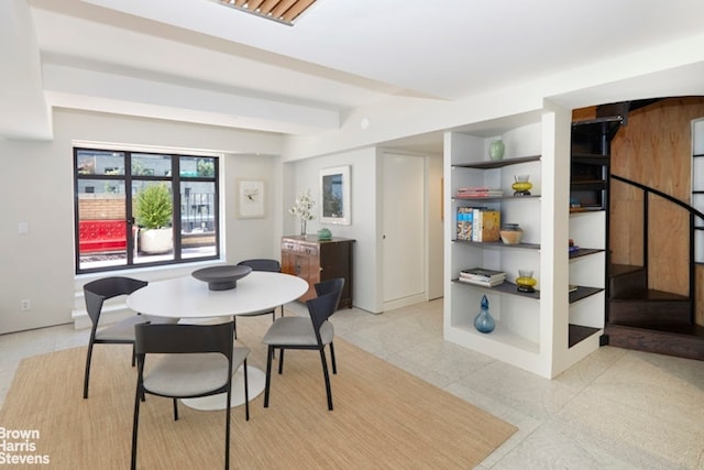 dining room featuring built in features, beamed ceiling, and light tile patterned flooring