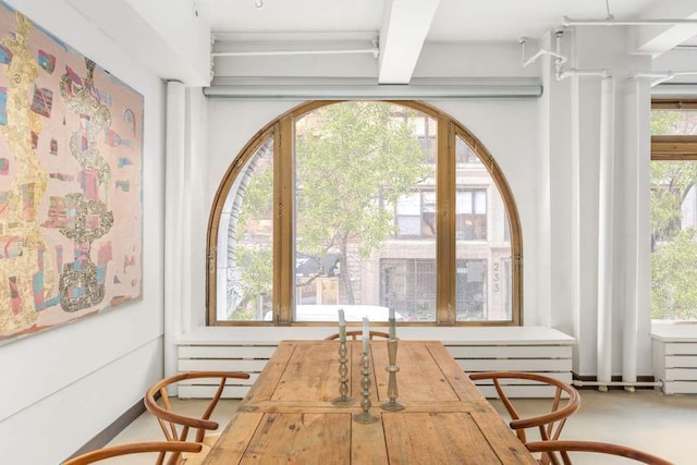 interior space featuring beamed ceiling and baseboard heating