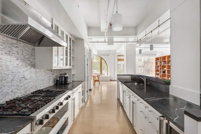 kitchen featuring sink, decorative backsplash, white cabinets, decorative light fixtures, and wall chimney exhaust hood