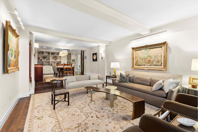 living room featuring dark wood-style flooring, beam ceiling, and baseboards