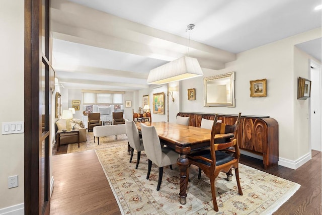 dining room with dark hardwood / wood-style floors and beam ceiling