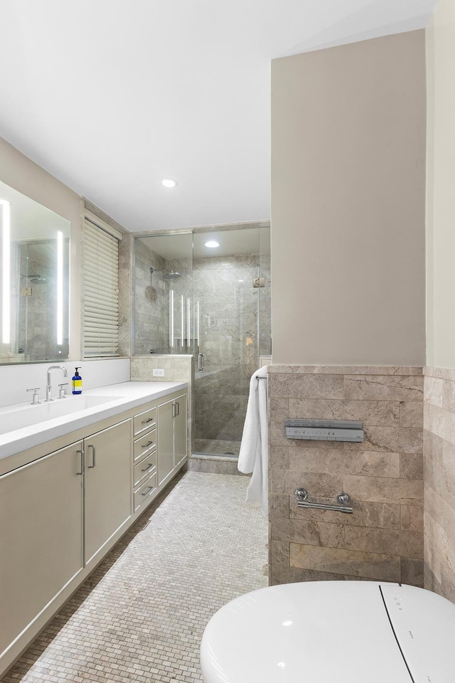 bathroom featuring tile walls, a shower stall, and vanity