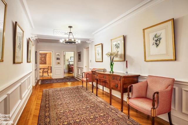 corridor with a notable chandelier, ornamental molding, and hardwood / wood-style floors